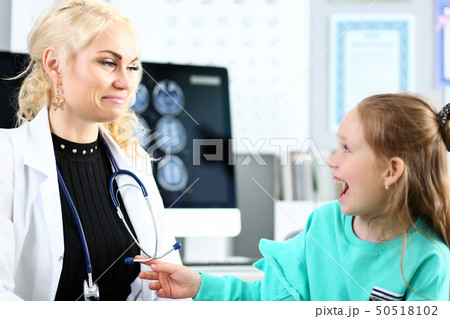 Enthusiastic cute little patient laughing at doctor office during tests 50518102