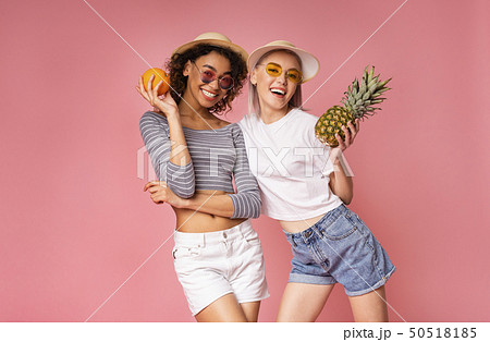 Healthy young women posing with fresh orange and pineapple 50518185