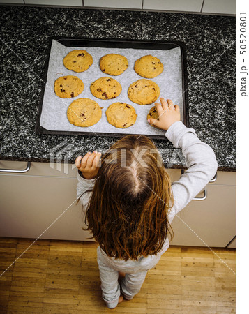 Young girl looking at freshly baked cookies 50520801