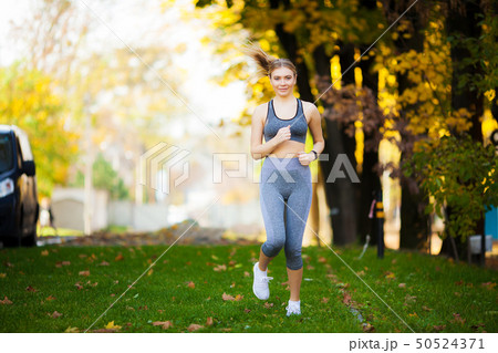 Fitness. Beautiful young woman doing exercises in the park 50524371