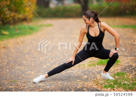 Fitness. Beautiful young woman doing exercises in the park 50524599