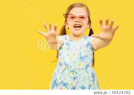 Beautiful emotional little girl isolated on yellow background 50524702
