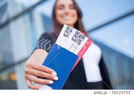 Travel. Closeup of girl holding passports and boarding pass at airport Travel. Closeup of girl holding passports and boarding pass at airport 50524703
