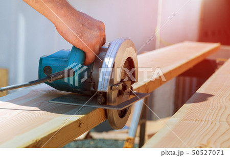 Cutting wood beam using an electrical chainsaw Cutting wood beam using an electrical chainsaw 50527071