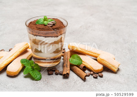 Classic tiramisu dessert in a glass and savoiardi cookies on concrete background 50529599