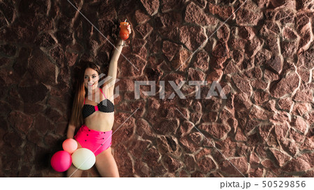 Woman with coctail and balloons on pool. 50529856