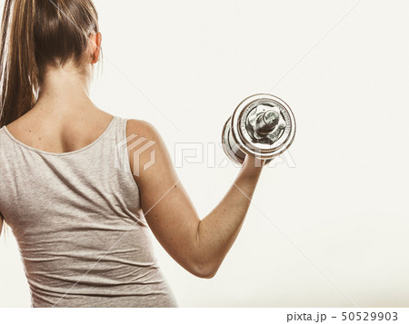 Strong woman lifting dumbbells weights. Fitness. 50529903