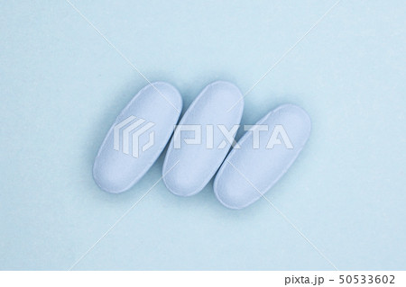Blue medical pills on light blue Blue medical pills on light blue 50533602