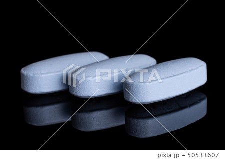 Blue medical pills isolated on black glass 50533607