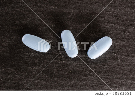 Blue medical pills on grey stone Blue medical pills on grey stone 50533651