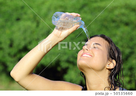 Attractive woman throwing herself water from a Attractive woman throwing herself water from a 50535660