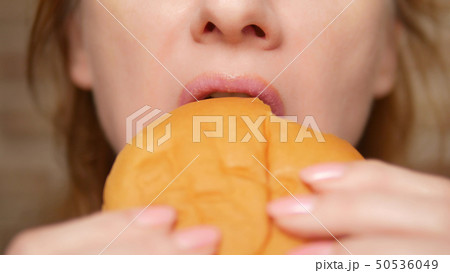 female mouth closeup. woman bites off a hamburger 50536049