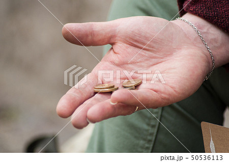 closeup of euros coins in hand of poor woman 50536113