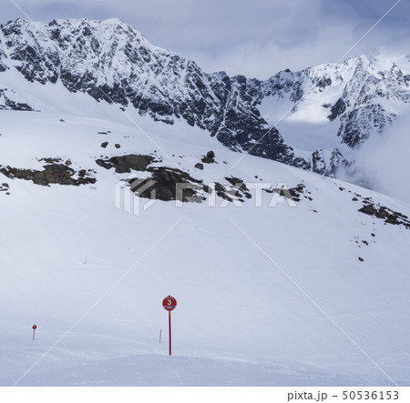 Winter landscape with empty red piste sign, snow covered mountain slopes, spring sunny day at ski Winter landscape with empty red piste sign, snow covered mountain slopes, spring sunny day at ski 50536153