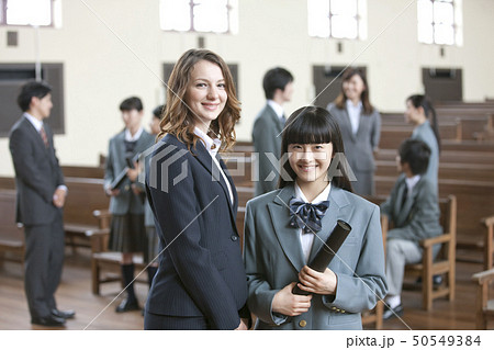 卒業証書を持つ女子校生と外国人教師 50549384