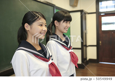 黒板の前に立つ女子校生2人 50549949