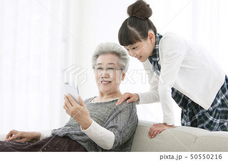スマートフォンを見る祖母と孫娘 50550216