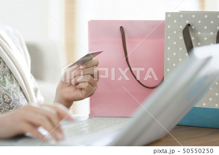 クレジットカードを持ってPCを使う女性の手元 50550250
