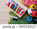 Colorful thread for sewing on wood background 50550917