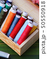 Colorful thread for sewing on wood background 50550918