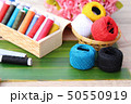 Colorful thread for sewing on wood background 50550919