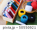 Colorful thread for sewing on wood background 50550921