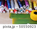 Colorful thread for sewing on wood background 50550923