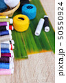 Colorful thread for sewing on wood background 50550924
