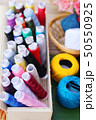 Colorful thread for sewing on wood background 50550925