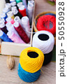 Colorful thread for sewing on wood background 50550928