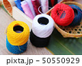 Colorful thread for sewing on wood background 50550929