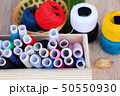 Colorful thread for sewing on wood background 50550930