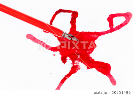 top view of red nib pen over red ink blot on white top view of red nib pen over red ink blot on white 50551499