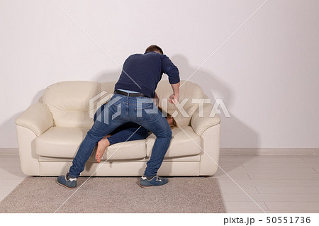 people, abuse and violence concept - aggressive man hitting his wife on sofa 50551736