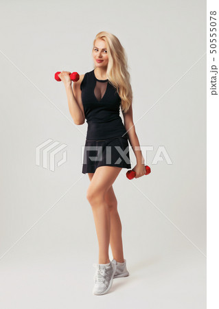 beautiful woman holding red dumbell beautiful woman holding red dumbell 50555078
