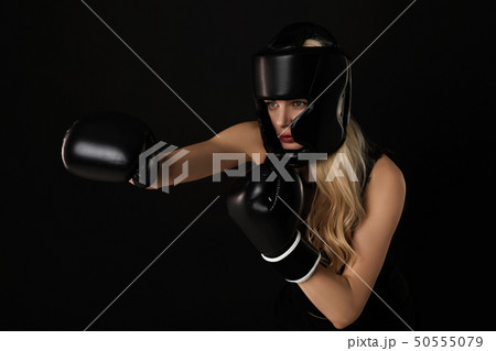 Portrait of woman posing in boxing gloves 50555079