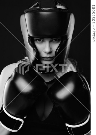 Portrait of woman posing in boxing gloves Portrait of woman posing in boxing gloves 50555081