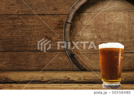 Wooden barrel and glass of beer on a old oak table 50556480