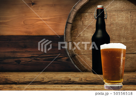 Wooden barrel and glass of beer on a old oak table Wooden barrel and glass of beer on a old oak table 50556518