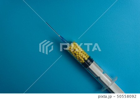 Syringe filled with colorful nano balls on a blue Syringe filled with colorful nano balls on a blue 50558092