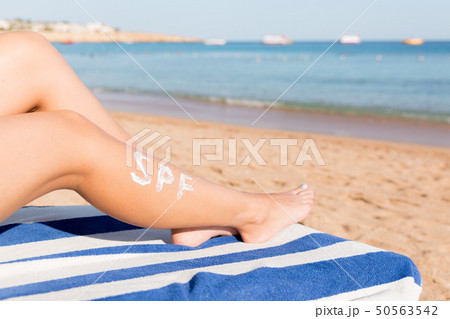 Tanned woman with sunscreen on body 50563542