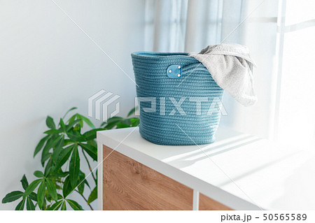 Laundry basket with gray towel. Interior of white stylish room with laundry basket Laundry basket with gray towel. Interior of white stylish room with laundry basket 50565589