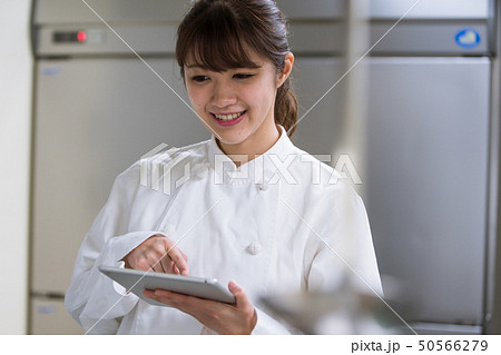タブレット端末で調理方法を確認する調理師 50566279