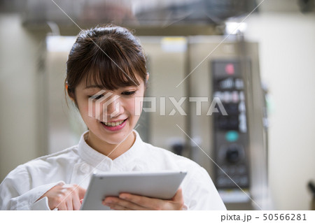 タブレット端末で調理方法を確認する調理師 50566281