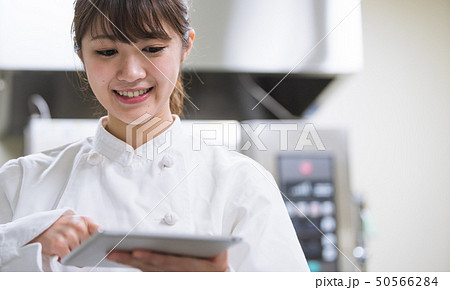 タブレット端末で調理方法を確認する調理師 50566284