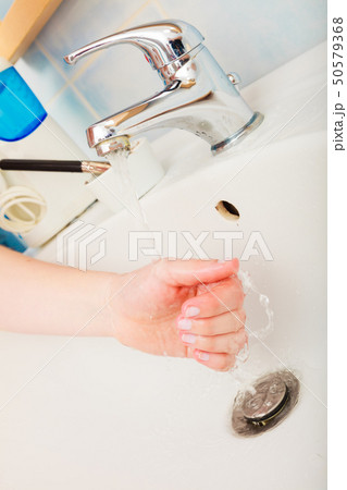 Woman washing hands under flowing tap water Woman washing hands under flowing tap water 50579368