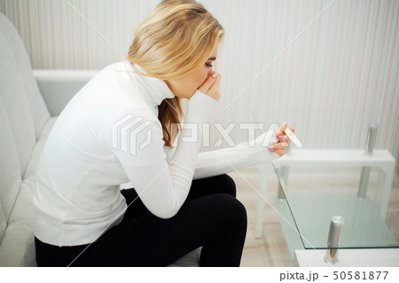 Pregnancy test. Worried sad woman Looking at a Pregnancy Test after result Pregnancy test. Worried sad woman Looking at a Pregnancy Test after result 50581877