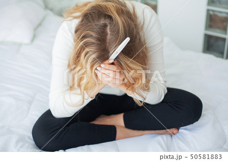 Pregnancy test. Worried sad woman Looking at a Pregnancy Test after result 50581883