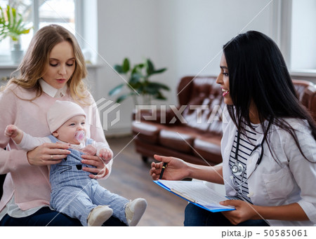 Mother with baby visiting pediatrician 50585061