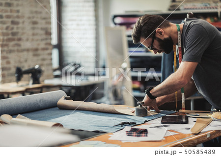 Fashion designer working in his studio Fashion designer working in his studio 50585489